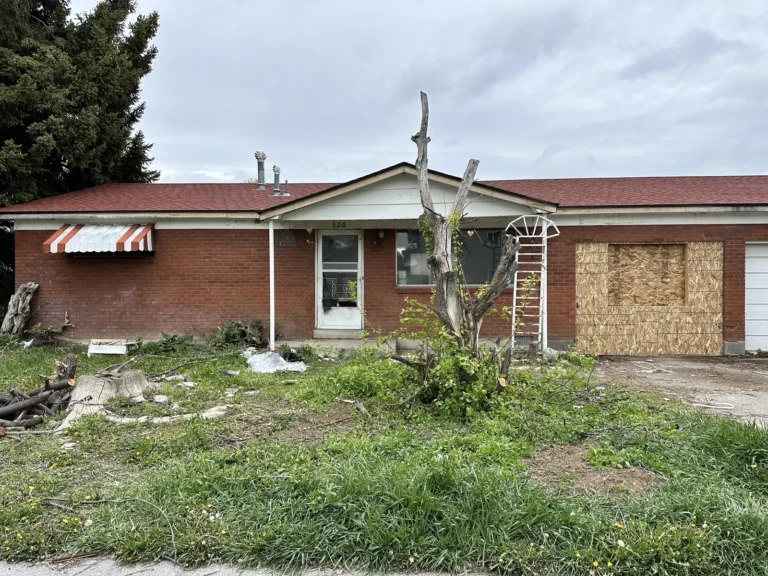 Brick house with plywood over the front window