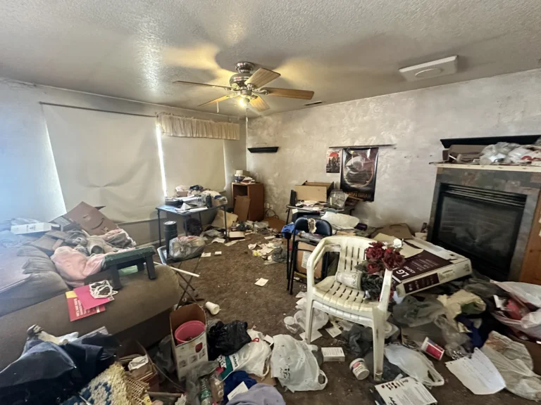 Cluttered living room with a fireplace and broken furniture