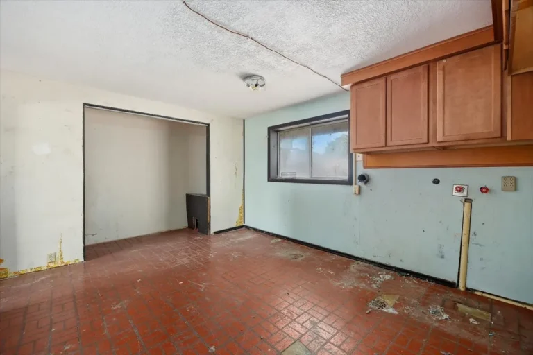 Empty room with old tile floor and stained walls