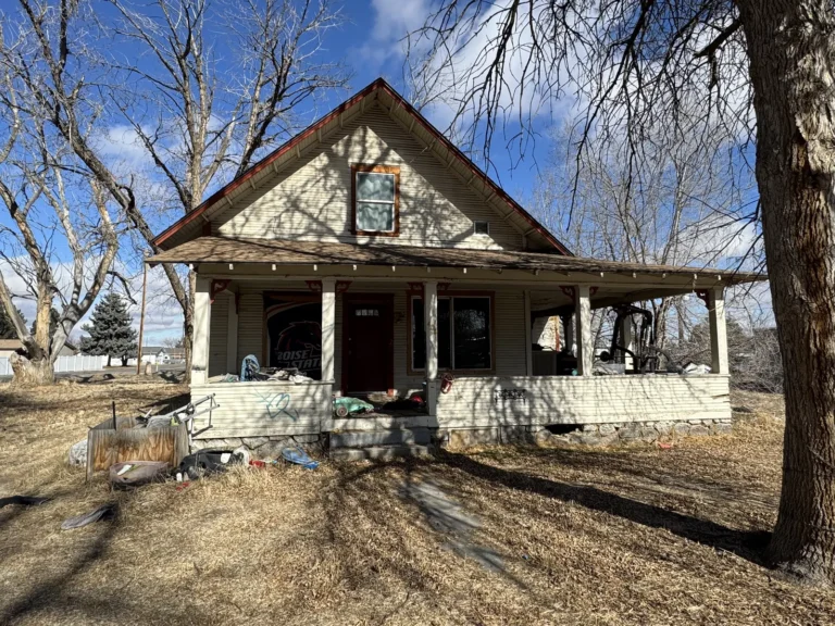 Older farmhouse with a sagging, damaged front porch