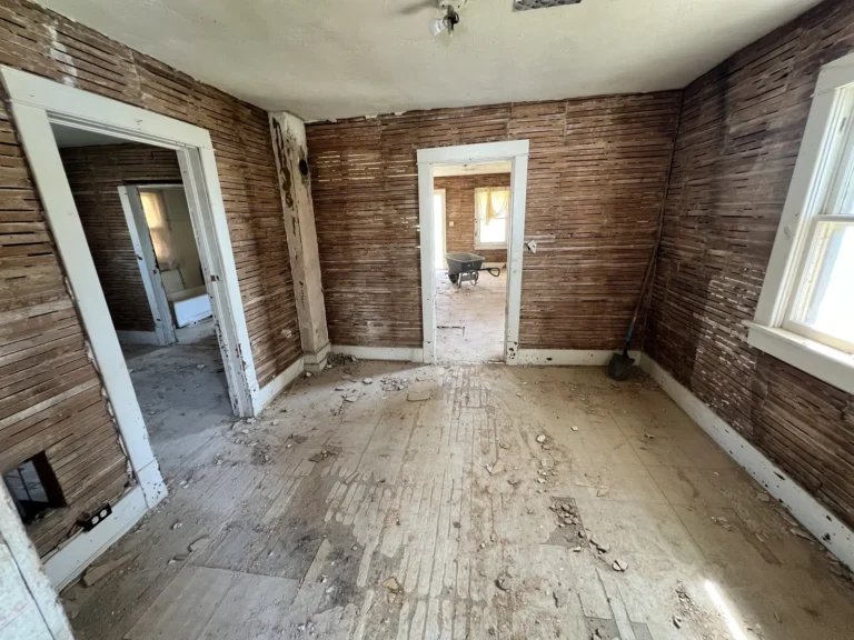 Living room stripped to bare wood walls