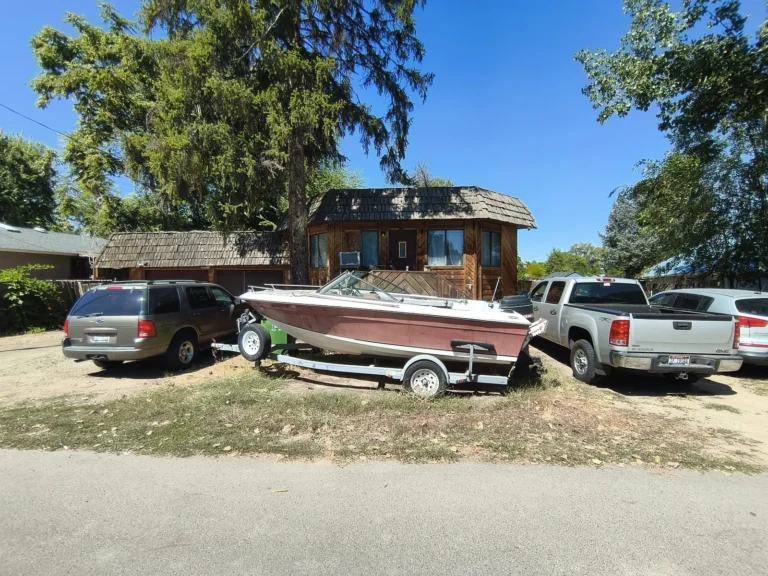 House with a boat and trucks parked in the yard