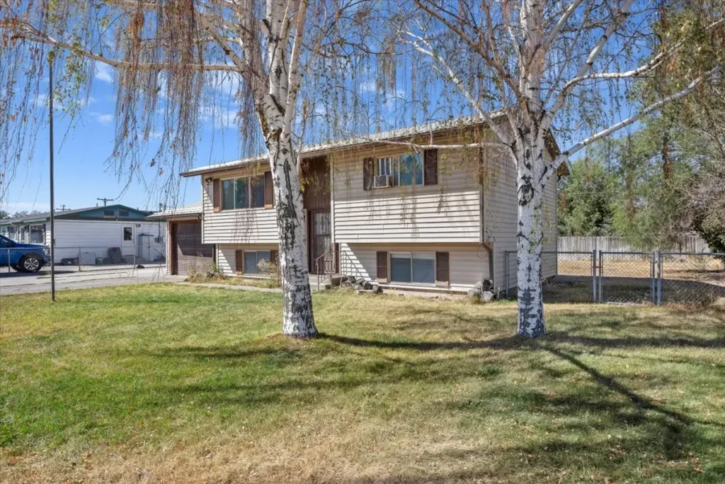 Two-story house with a raised deck and birch trees